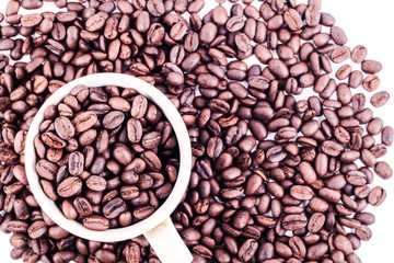 Cup of coffee full of coffee beans from top view