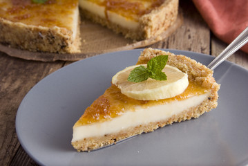 Piece of homemade lemon or citrus tart. Sweet cake with lemon and citrus jam on grey plate. Close up dessert.