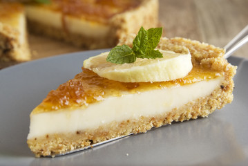 Piece of homemade lemon or citrus tart. Sweet cake with lemon and citrus jam on grey plate. Close up dessert.