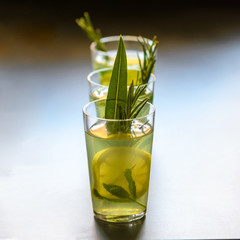 Mojito cocktail, lime, mint  and ice in glass decorated with herbs on dark background.
