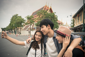 Young man is discussing with their friends about the way to go by map at the street