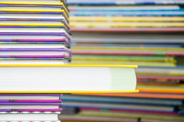 A stack of colored books with one big book poking out.