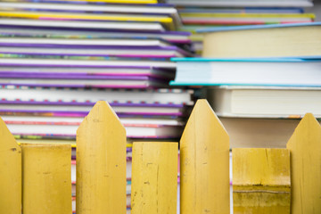 A stack of colorful books behind the hedge.