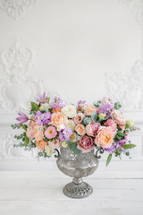 Gorgeous bouquet of different flowers. floral arrangement in vintage metal vase. table setting....