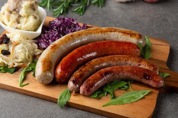 Grilled sausages with mash potatoes on wooden board