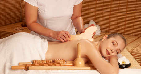 Beautiful young woman having a maderotherapy massage  treatment in spa salon - wellness