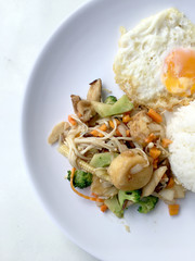 Stir fry yellow tofu and vegetable with rice and fried egg in white dish on white background for celebrate Chinese new year festival. Healthy food. Thai food.