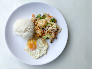 Stir fry yellow tofu and vegetable with rice and fried egg in white dish on white background for celebrate Chinese new year festival. Healthy food. Thai food.
