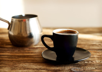 a cup of coffee on a wooden table