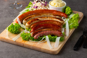 Grilled sausages on wooden board