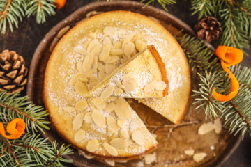 Traditional Christmas (Norwegian) almond pie in Christmas decorations, dark background.