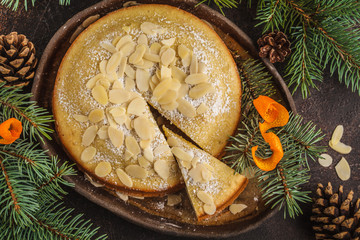 Traditional Christmas (Norwegian) almond pie in Christmas decorations, dark background.