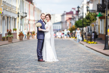 loving couple of newlyweds walks in the old city in summer sunny day