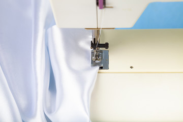 Sewing machine and white satin fabric