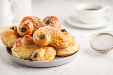 Traditional Swedish saffron buns and coffee, white background, European breakfast.