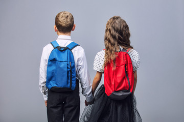 Kids boy and girl in school uniform with backpacks fashionable beautiful and confident in Studio on...