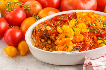 Tomato vegetarian pie with chickpeas and parsley in white dish. Clean eating concept.