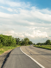 Naklejka premium Comfortable journey of beautiful landscape street and trees beside with blue sky and clouds on sunlight.
