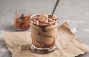 Vegan chocolate ice cream in a glass jar. Healthy dessert. Gray background.