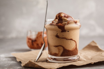 Vegan chocolate ice cream in a glass jar. Healthy dessert. Gray background.