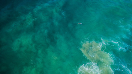 Surfers on beautiful day enyouing the waves in Australia, photographed from above using a drone.