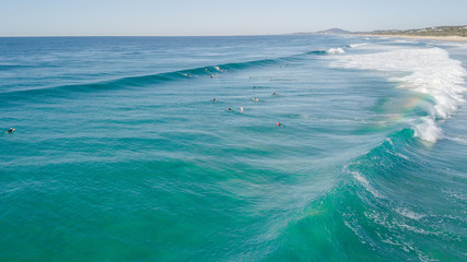 Surfers on beautiful day enyouing the waves in Australia, photographed from above using a drone.