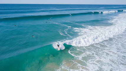 Surfers on beautiful day enyouing the waves in Australia, photographed from above using a drone.