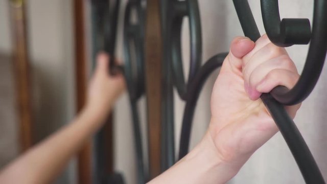 women's hands clinging to the forged head of the bed. forged beds, details. 4k, slow motion.