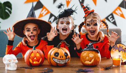 happy Halloween! a group of children in suits and with pumpkins in home - obrazy, fototapety, plakaty