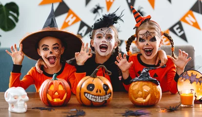Foto op Plexiglas happy Halloween! a group of children in suits and with pumpkins in home © JenkoAtaman