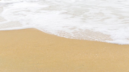 Fototapeta na wymiar Soft wave foam on sandy beach