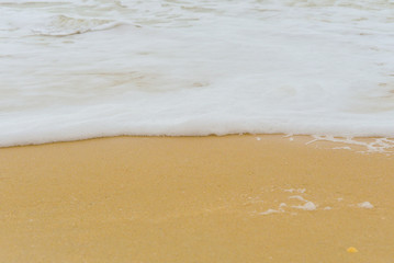 Soft wave foam on sandy beach