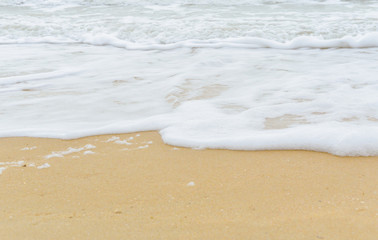 Soft wave foam on sandy beach