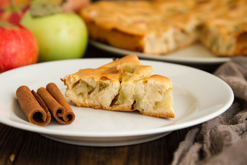 piec of an apple pie on a white plate on a wooden table