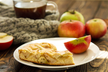 piec of an apple pie on a white plate on a wooden table