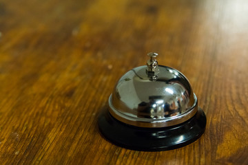 Hotel service call bell on wooden reception front desk