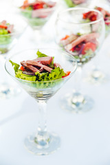 wine glasses with salad and meat snack at reception. catering snack service