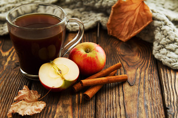 glass Cup with a hot drink with a sliced Apple on a wooden background