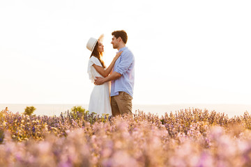 Photo of european young man and woman, walking outdoor in lavender field