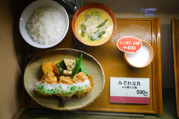 Display of replica food and desserts with prices in a sweet restaurant window in Tokyo, Japan.