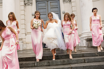 Wedding help. Bridesmaids and bride walking after wedding ceremony without groom and groomsmen
