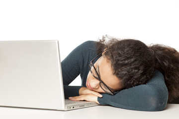 tired young african woman sleeping on the laptop.