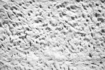 Detailed imperfect white texture of aerated foam block with holes close-up. Side of building is painted whitish. Background of construction from foamed material in macro. Decorative facing of house.