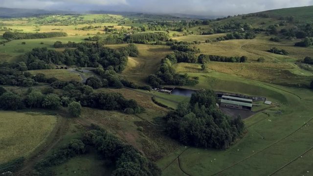 Aerial view, tilt down move. Drone panorama of green plains near Llyn Celyn water reservoir in Wales. Traweryn river