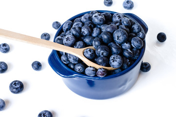 Fresh sweet blueberry fruit in spoon in bowl. Shallow depth of field