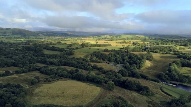 Aerial view, fly down move. Drone panorama of green hills near Llyn Celyn water reservoir in Wales. Traweryn river