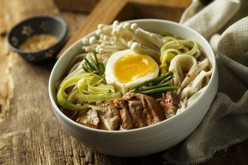 Asian style soup with noodles, egg, meat and mushrooms