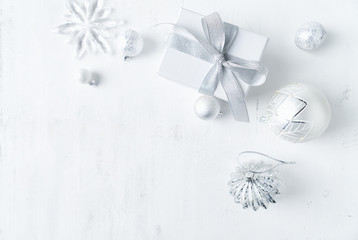 Christmas present with white and silver Christmas decorations. Flatlay. Copy space