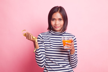 Asian woman drink orange juice hold measuring tape.