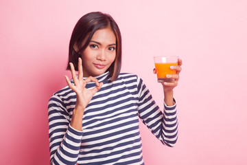 Young Asian woman show OK drink orange juice.
